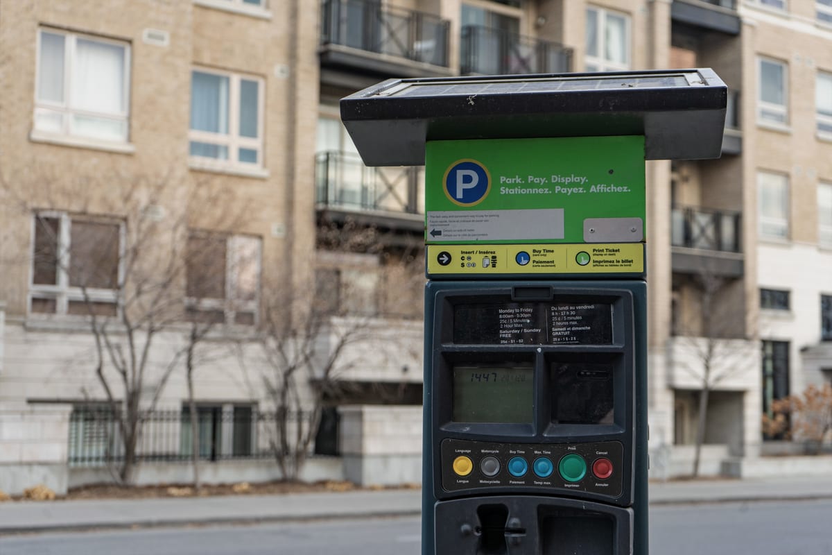 Close up of a self service parking payment machine keypad and screen, tinted toward Parka teal, with no faces, plates or branding visible.